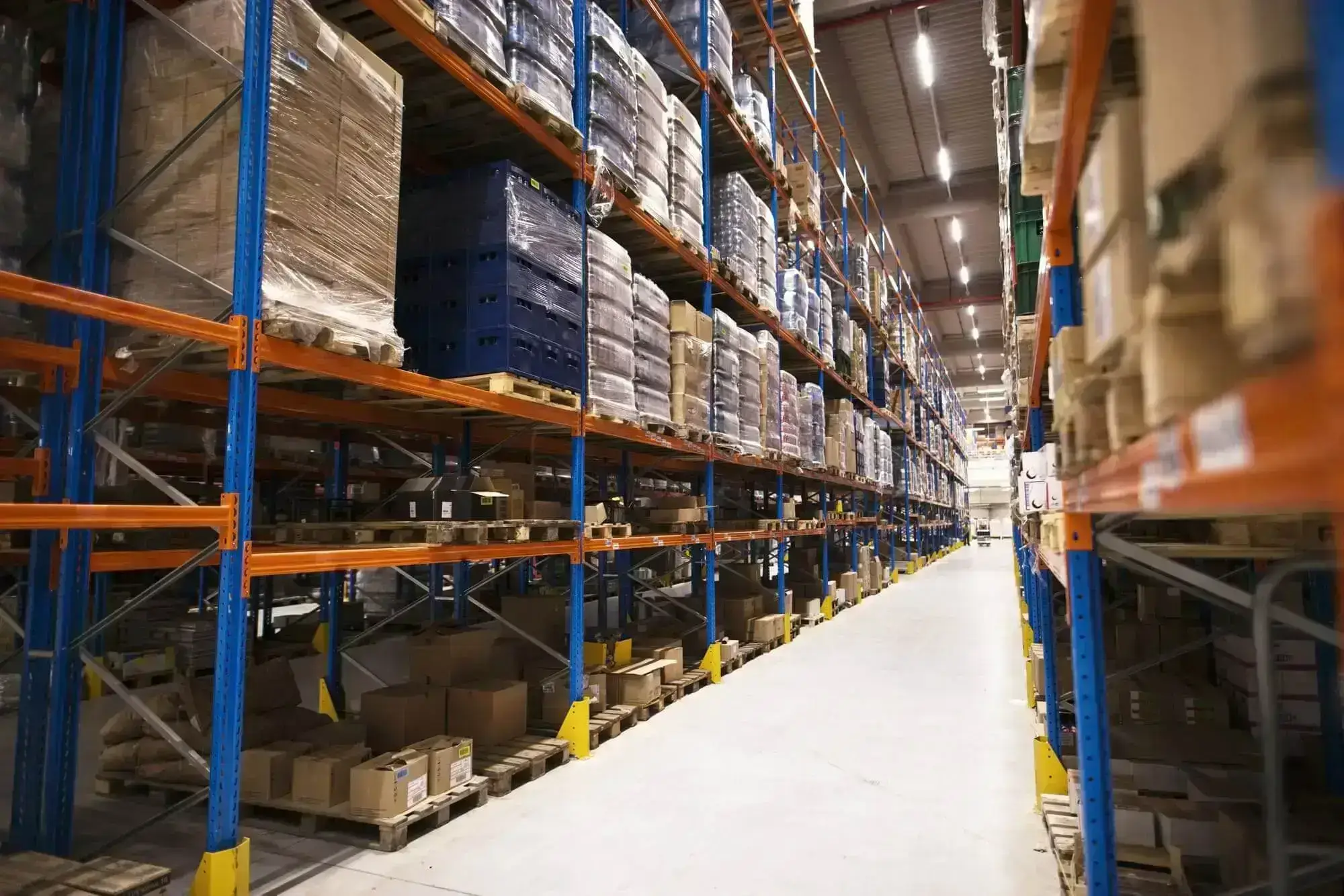 interior del gran almacen de distribucion con estantes apilados con paletas y productos listos para el mercado (2)